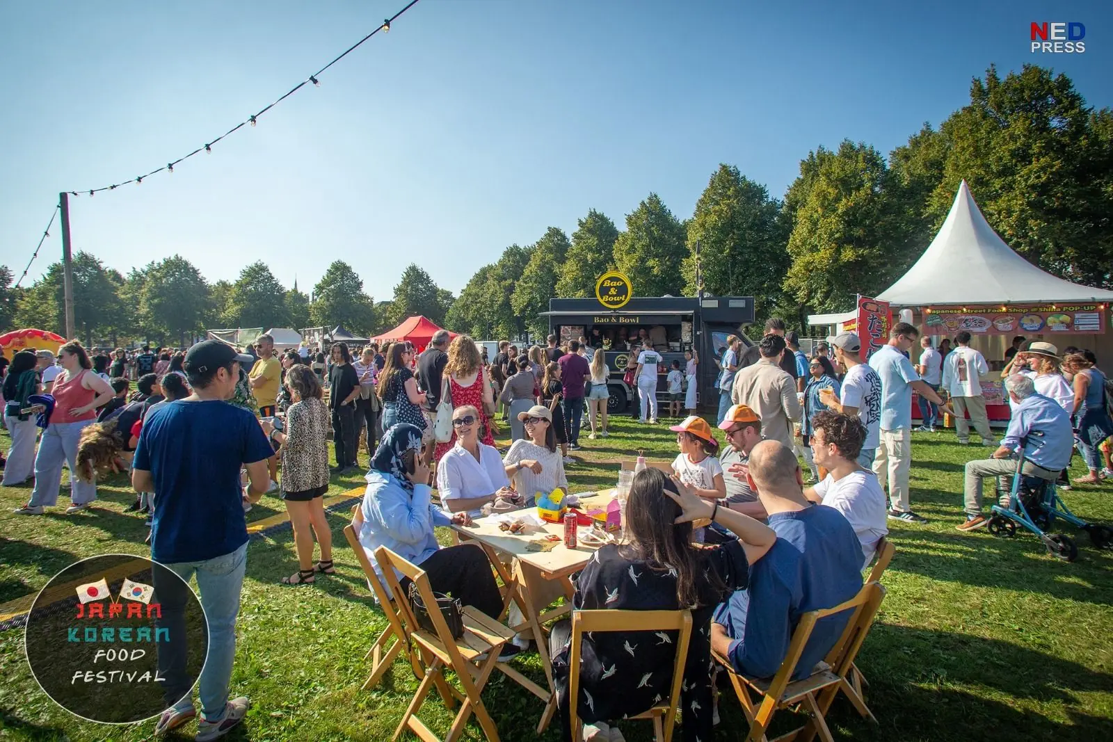 Bezoekers eten samen aan lange tafels